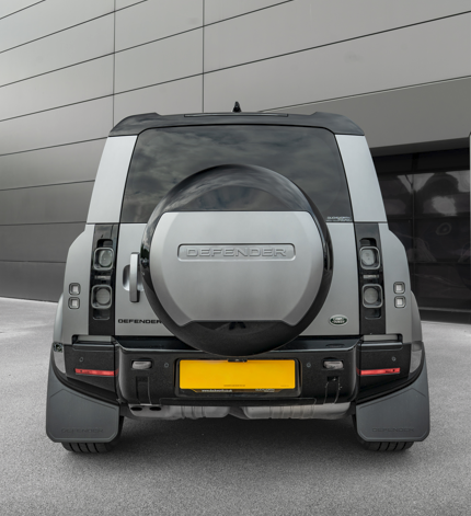 Rear view of a silver off-road vehicle with a spare tyre on the back.