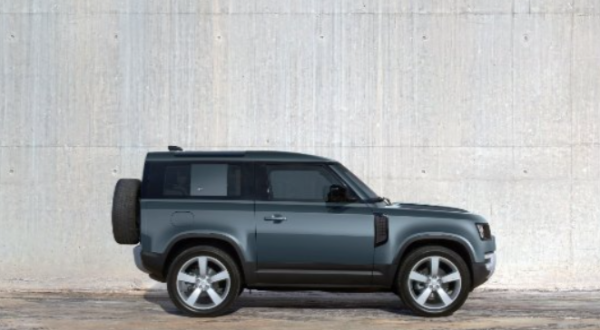 Side view of a dark grey 4x4 vehicle parked on a concrete surface.
