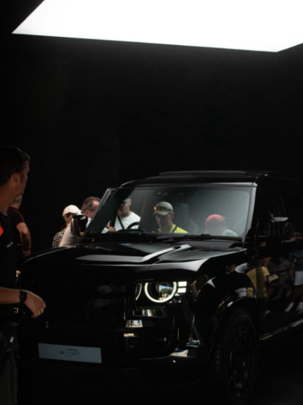 Black SUV on display with a crowd of people around it.