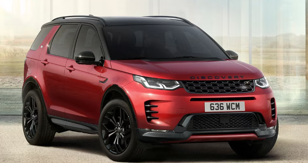 Red Land Rover Discovery Sport 4x4 viewed from the side, parked on a light surface.