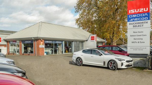 Car dealership featuring multiple vehicles and a visible Isuzu sign.