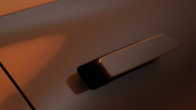 Close-up of a car's bronze exterior with a sleek door handle.