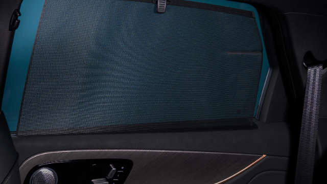 Car window equipped with a sunshade and built-in speaker.