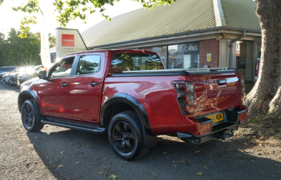 Red pickup truck parked beside a building.