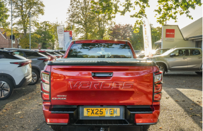 Red Isuzu D-Max V-Cross parked at a dealership with several other vehicles.