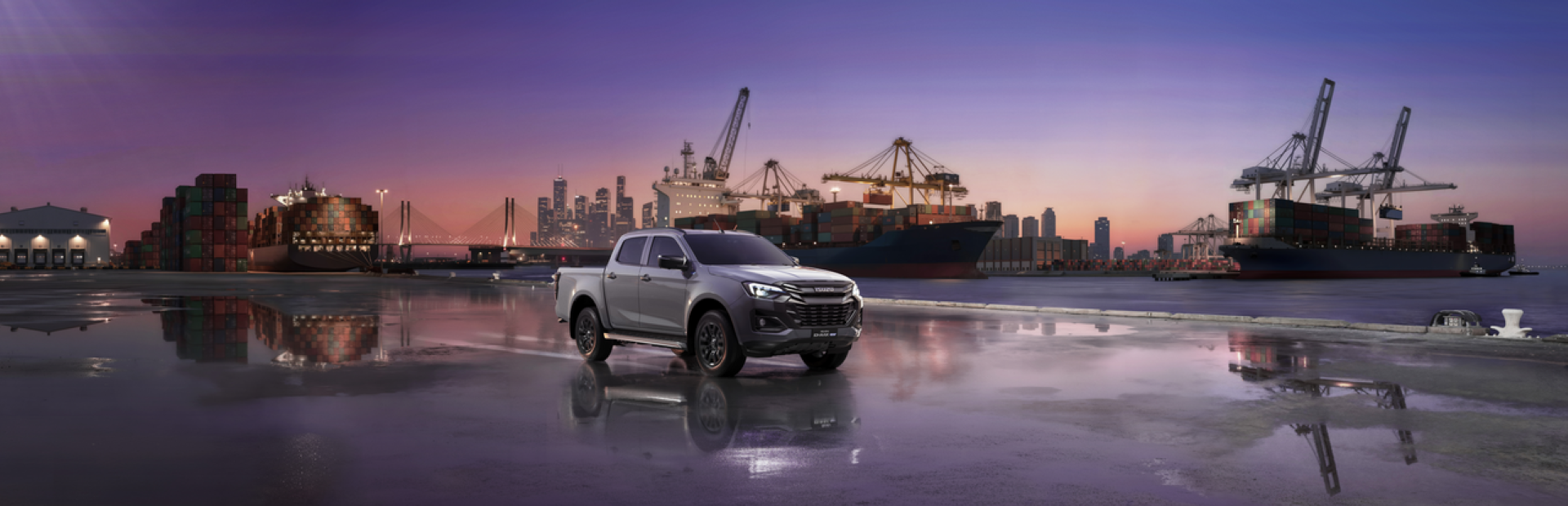 Pickup truck parked near shipping containers and cranes at a harbour.