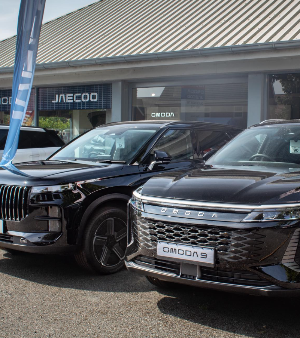 Two black vehicles parked beside a building, with visible vehicle logos on the front.