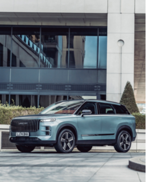SUV parked in front of a modern building with large windows.