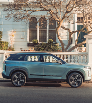 Light blue SUV parked on a city street, side view.