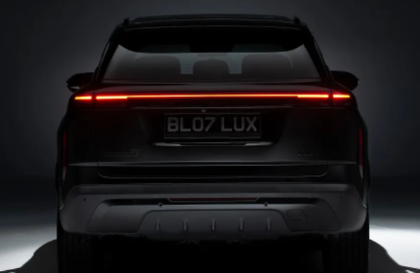 Rear view of a car with illuminated tail lights and the number plate BL07 LUX.