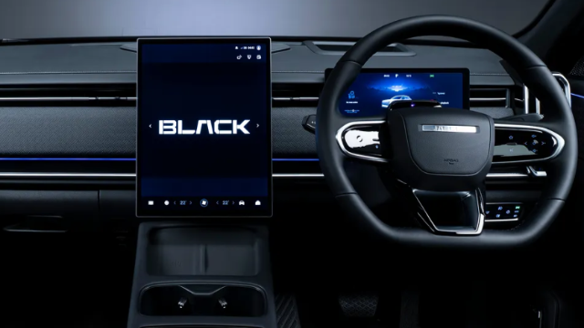 Steering wheel and touchscreen display inside a car interior.