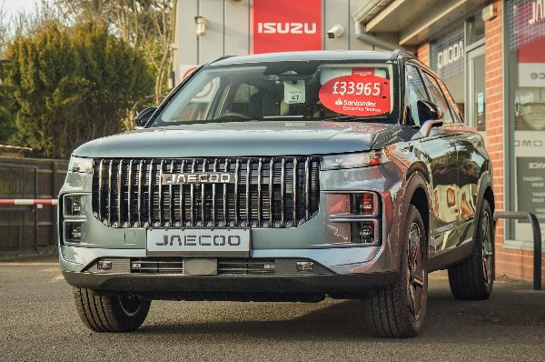 Silver Jaecoo SUV parked in front of dealership with £33,965 sticker on windscreen.