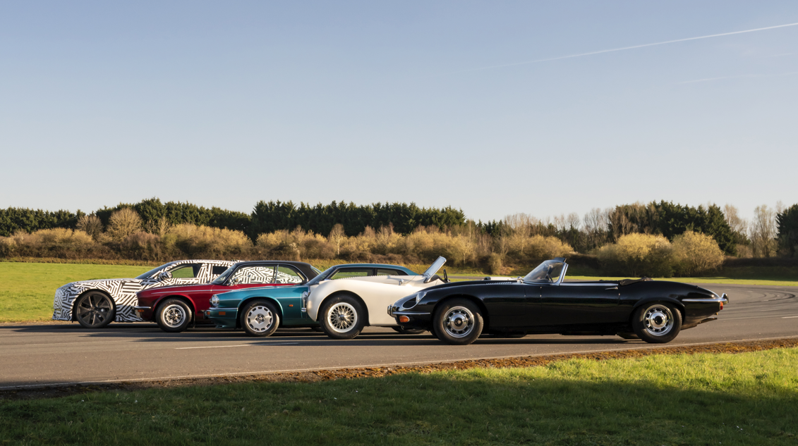 Four classic cars parked in a line on a road, side view.
