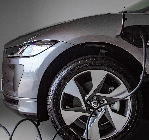 Electric car charging with visible cable connected to front side port.