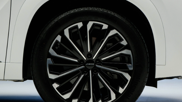 Close-up of a car's rear wheel with a black and silver alloy rim.