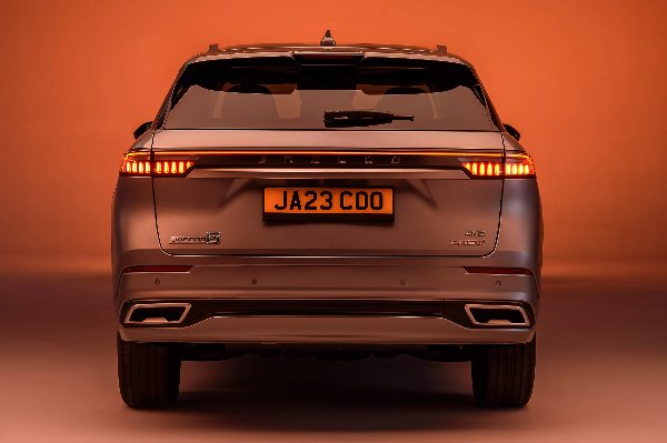 Rear view of a silver SUV with licence plate JA23 COO lit by red taillights.