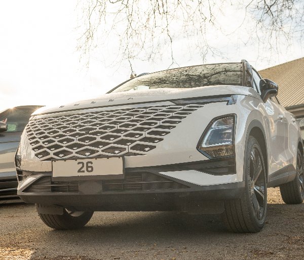 Front view of a white car with a distinctive grille and LED headlights.