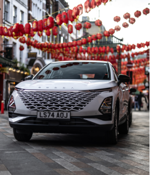 White SUV on a street decorated with red lanterns.