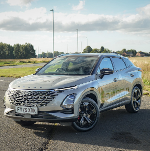A silver SUV parked on a road with grass fields in the background.