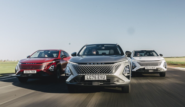 Silver SUV parked in front of a large, corrugated metal structure.