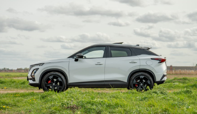White SUV parked on grass with a cloudy sky.