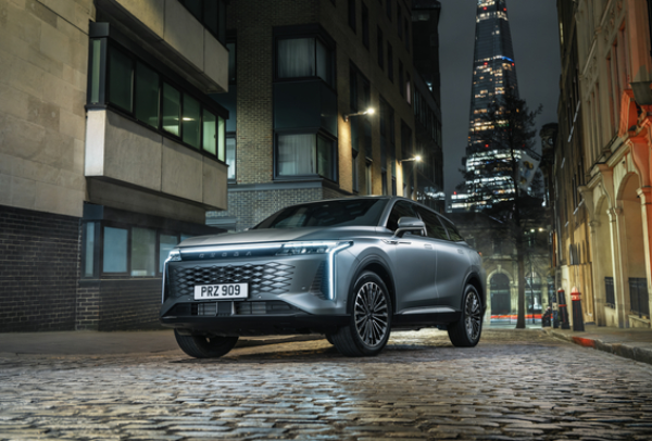 Silver car parked on a cobblestone street at night, with the Shard in the background.