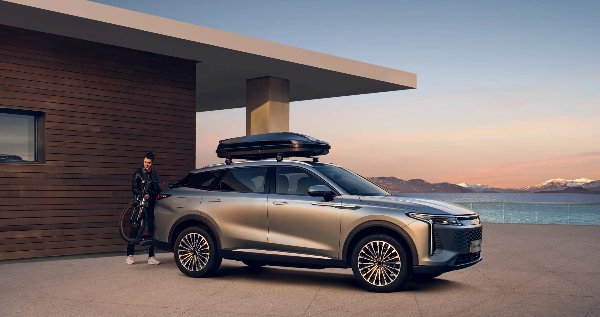 Silver SUV with roof box parked next to house, man placing bicycle on rear mount.
