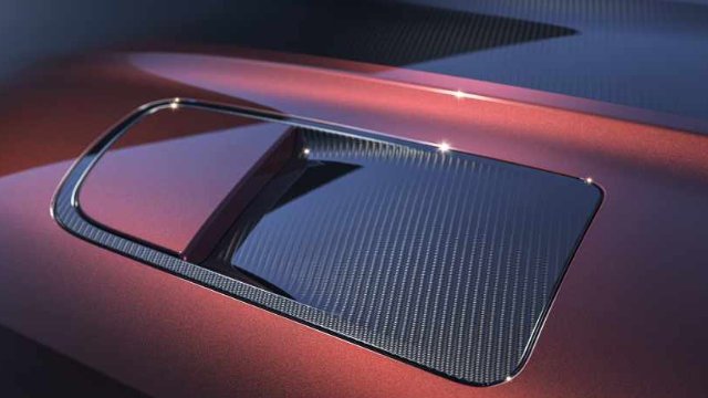 Close-up of a red car roof with a carbon fibre sunroof detail.