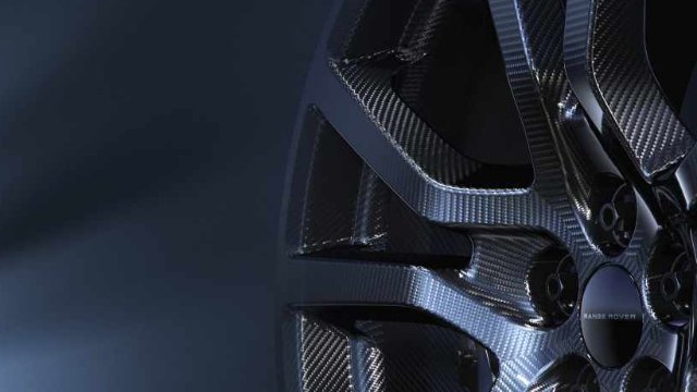 Close-up of a car wheel with a carbon fibre design, featuring the Range Rover logo.
