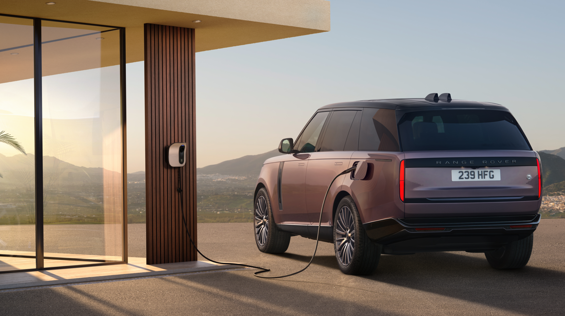 Electric SUV charging at a wall-mounted EV charger.