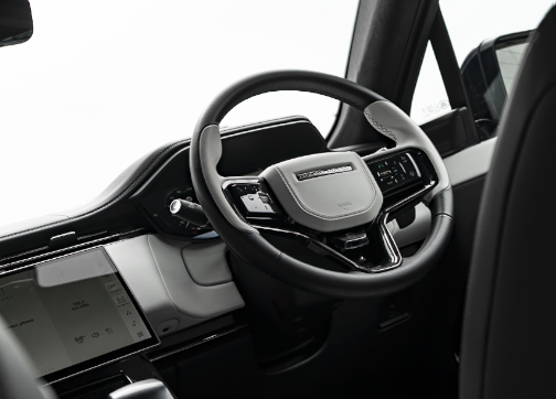 Steering wheel and dashboard of a modern vehicle with touchscreen display.