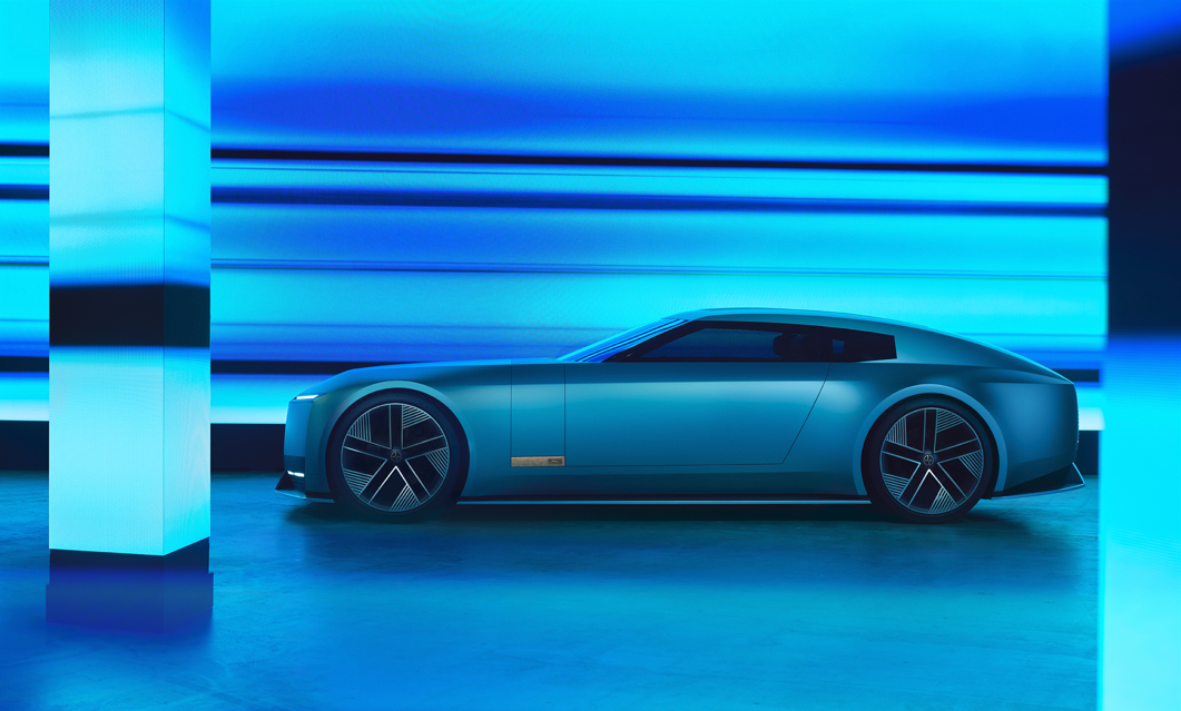 Sleek blue futuristic car with distinctive alloy wheels viewed from the side.
