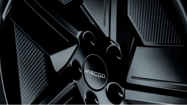 Close-up of a black car wheel with a five-spoke design and textured details.